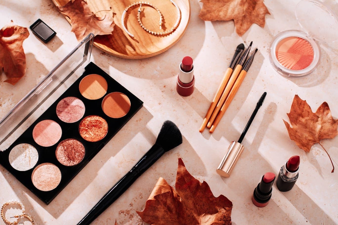 Makeup palette, lipsticks, and brushes from a beauty brand