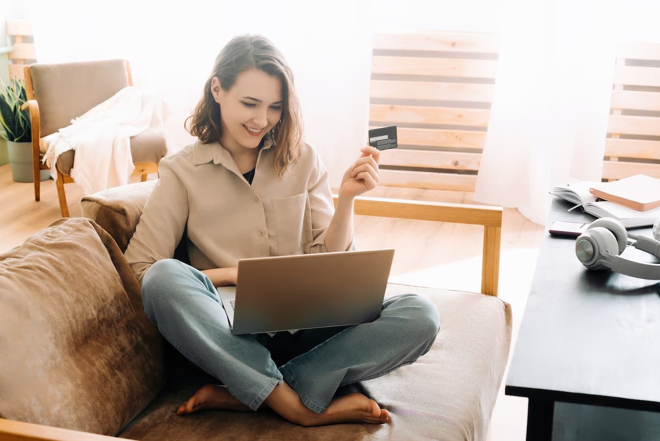 Customer holding a credit card while paying online on a laptop