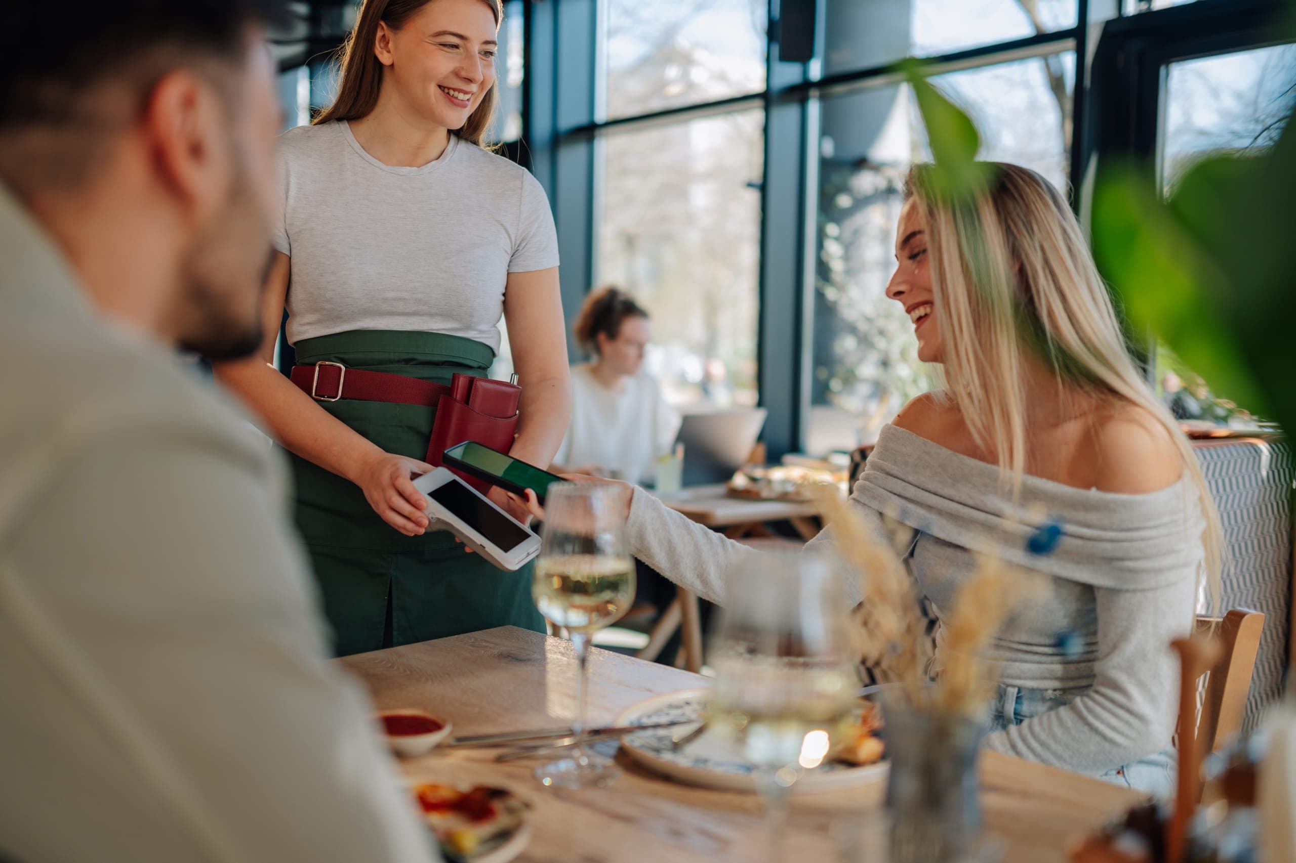 Waitress using a high-risk POS system to take a customer payment