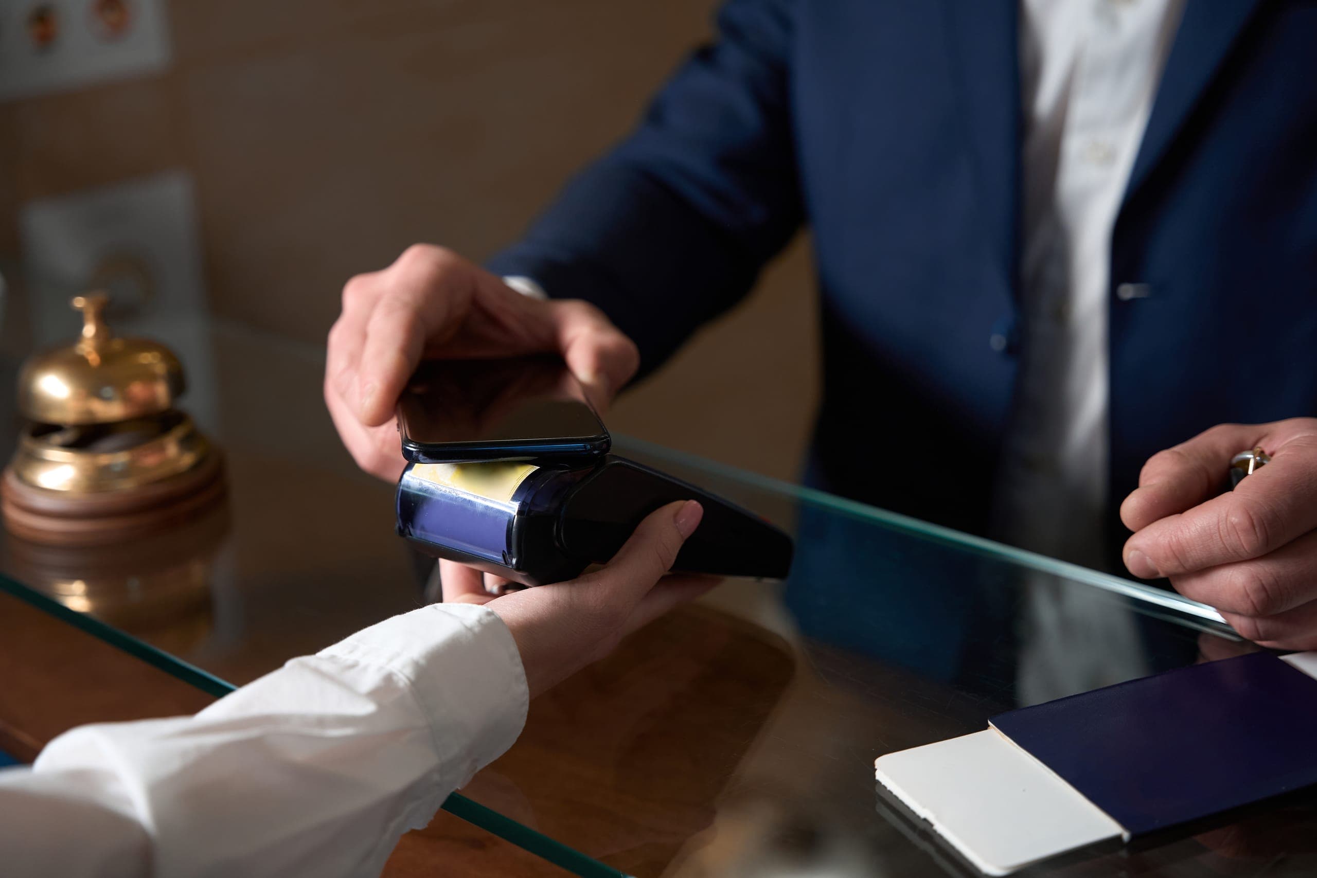 Businessman using an NFC POS device for hotel payment processing