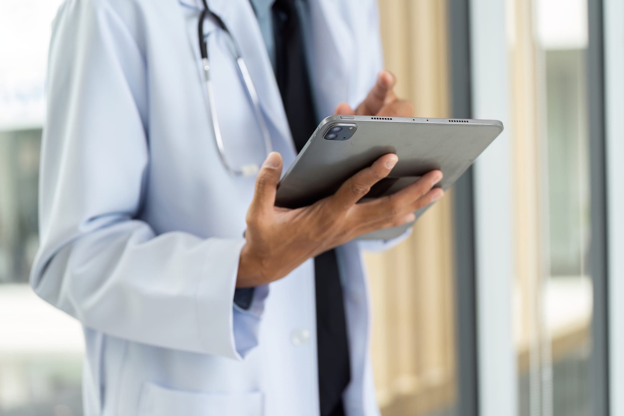 Doctor reviewing health care payment processing on a tablet
