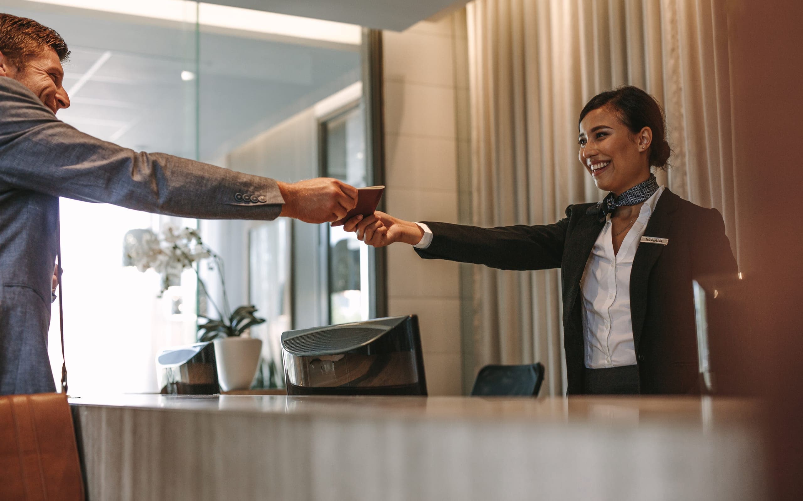 Hotel receptionist accepting a guest payment at the front desk