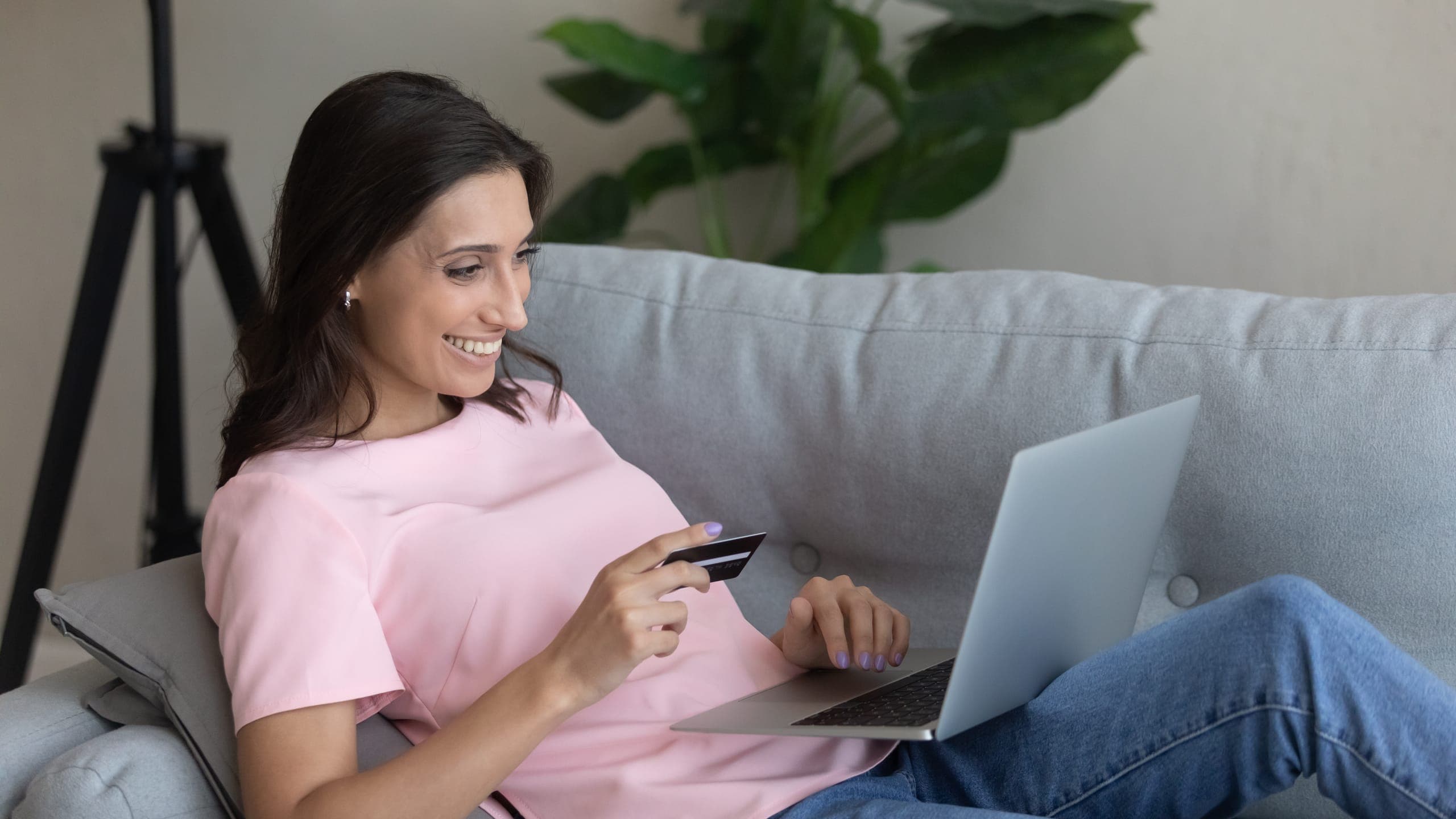 Woman using an online payment processing service to pay by card on her laptop